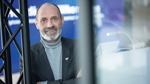 Chief Inspector Hans Hülsbeck from the LKA shows himself in the new showroom. He is smiling. A large screen can be seen in the background.